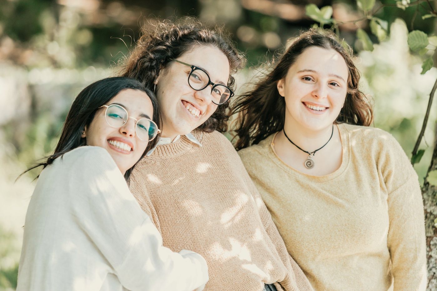 Three young women laughing together outdoors