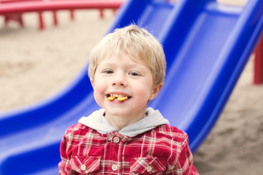 A little boy grinning at a playground