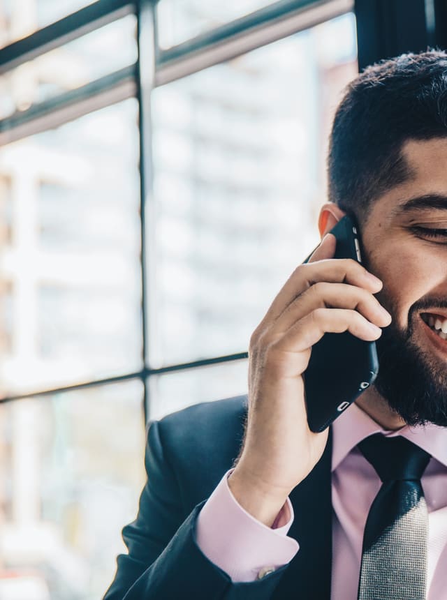 A man on the phone, smiling with relief