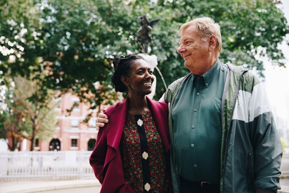 An older couple laughing together in a park