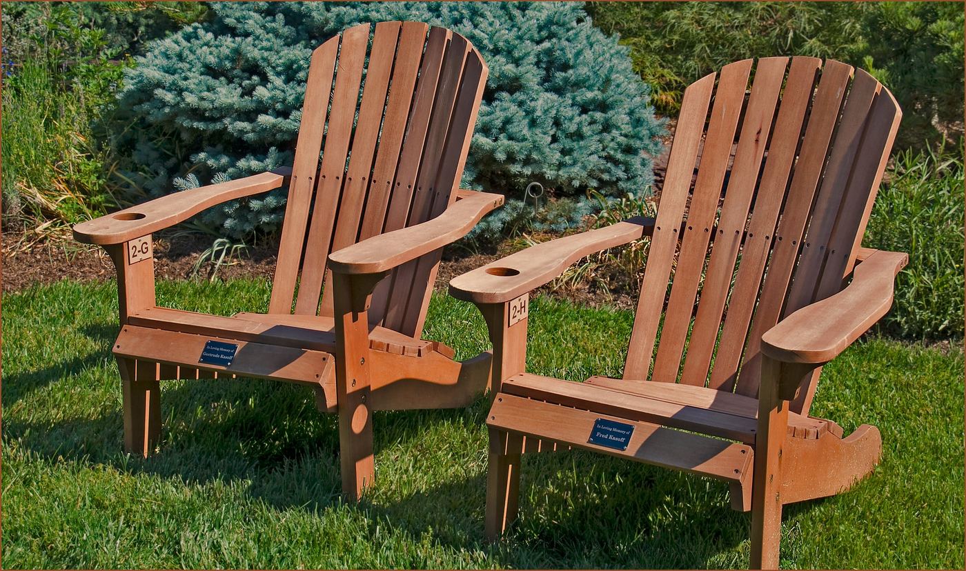 Two wooden lawn chairs on the grass at Meadowlark Botanical Gardens