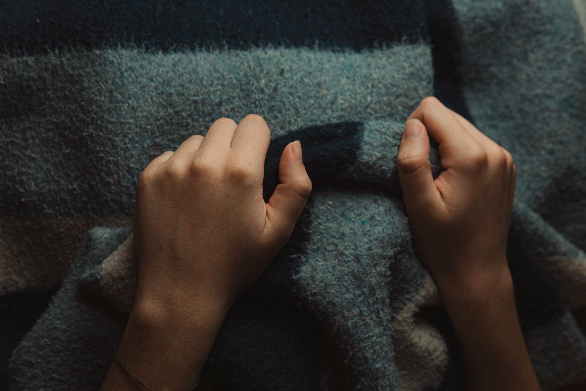 Hands gathering a thick wool blanket