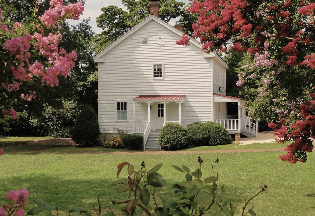 The white Freeman Store framed by crape myrtles
